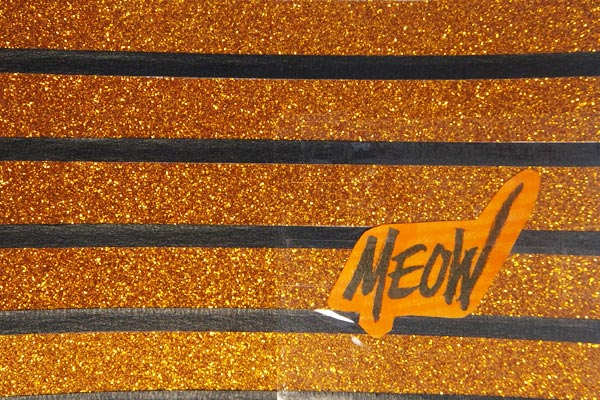 postcard-sized artwork of orange glitter stripes with word meow