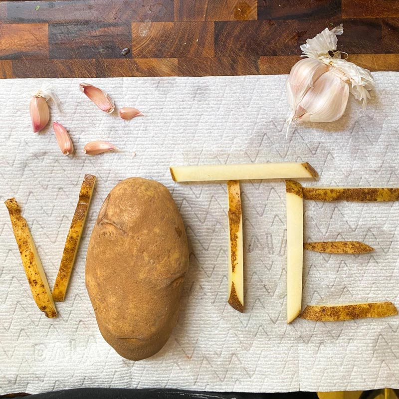 potato and cut potatoes for fries with garlic arranged to spell vote