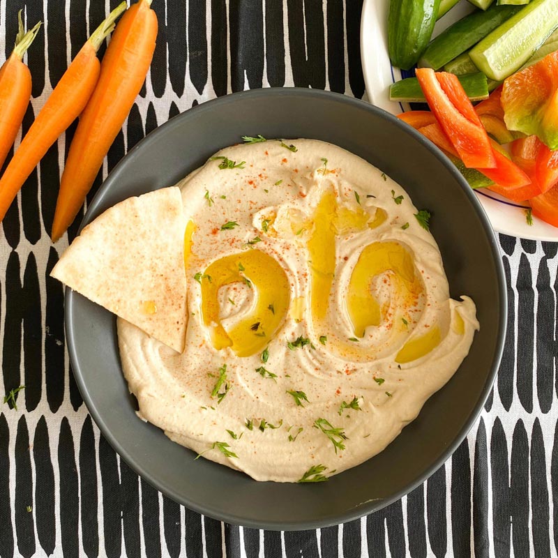 Word vote swirled into bowl of hummus with pita bread